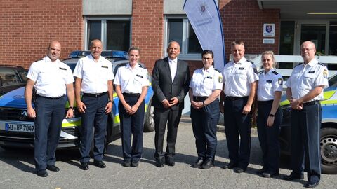 Innenminister Poseck mit den Beamtinnen und Beamten vor dem Polizeirevier.