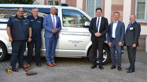 Mehrere Männer stehen vor Auto mit der Aufschrift Kampfmittelräumdienst