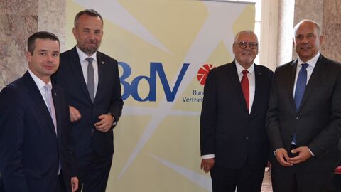 Innenminister Roman Poseck steht mit drei weiteren Männern vor einem Plakat mit der Aufschrift BdV - Bund der Vertriebenen.