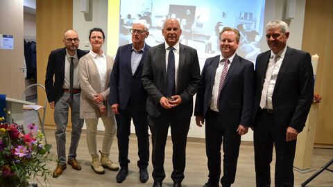 Sechs festlich gekleidete Personen stehen in einer Reihe