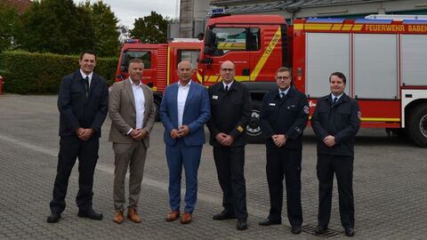 Mehrere Personen stehen vor Feuerwehrauto