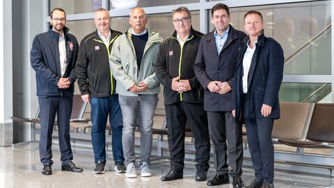 Innenminister Poseck und weitere Personen stehen zusammen vor einer Glaswand.