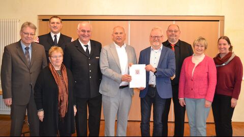 Heimatschutzminister Roman Poseck überreicht Bürgermeister Volker Becker den Zuwendungsbescheid