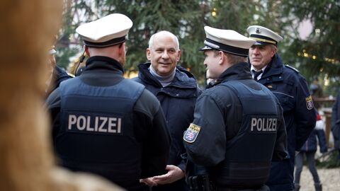 Mann mit Polizisten im Gespräch.