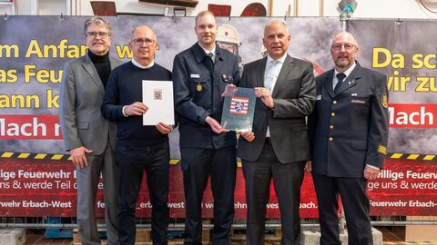 Heimatschutzminister Roman Poseck u. a. mit Bürgermeister Dr. Peter Traub und dem stv. Stadtbrandinspektor Jens Löb bei der Bescheidübergabe.
