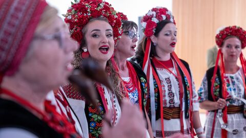 Frauen tragen traditionelle Kleidung und singen