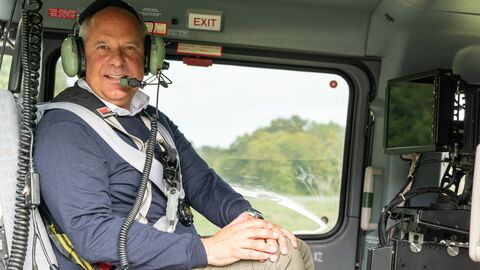 Nahaufnahme von Innenminister Poseck im Hubschrauber mit einem Headset.