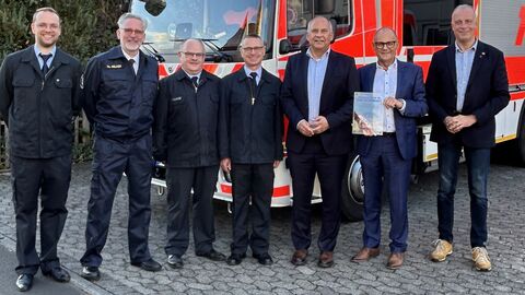 Herr Poseck steht mit weiteren Personen vor einem Feuerwehrwagen