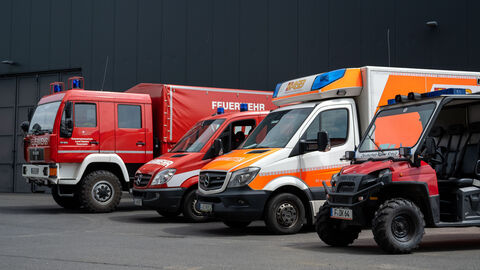 Einsatzfahrzeuge der Feuerwehr und Krankenwagen stehen auf einem Parkplatz