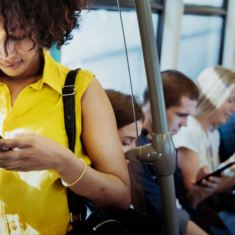 Junge Frau, die in der U-Bahn ein Smartphone benutzt Junge Frau, die in der U-Bahn ein Smartphone benutzt